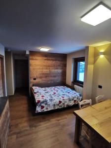 um quarto com uma cama e uma parede de madeira em La Stua Livigno em Livigno