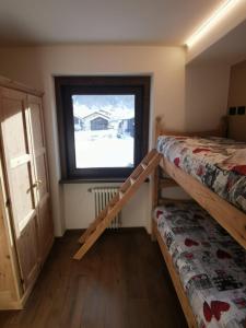 a bedroom with two bunk beds and a window at La Stua Livigno in Livigno