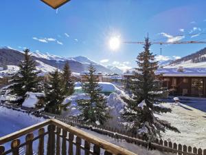 a view from a balcony with snow covered trees at La Stua Livigno in Livigno +9 photos