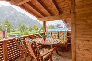 une terrasse couverte en bois avec une table et des chaises en bois dans l'établissement Ferienwohnung Jogglkessl, à Rohrberg