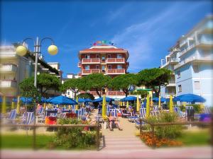 a resort with chairs and umbrellas and a building at Mon Repos in Lido di Jesolo