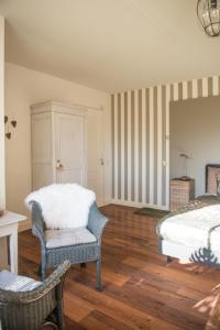 a bedroom with a bed and a chair at Broeks' Bed En Brood in Meerkerk