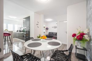 una sala de estar blanca con mesa blanca y sillas en Porta Aurea di Spalato, Luxury apartment, en Split
