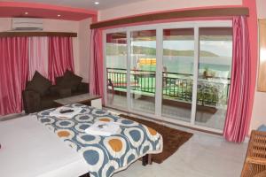 a bedroom with a bed and a view of the ocean at The Seaview Residency in Port Blair +21 photos