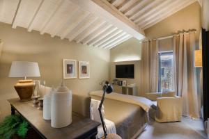 een slaapkamer met een bed en een tafel met een lamp bij Villa Sassolini Country Boutique Hotel in Montevarchi