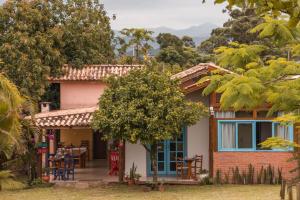 a house with a table and chairs in front of it at Pousada Waikiki in Praia do Rosa
