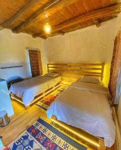 two beds in a room with wooden floors at Aliya Konak - Köy Evi ve Lezzetleri in Isparta