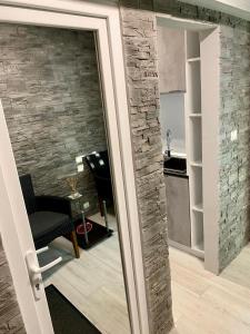 uma porta de vidro deslizante para uma cozinha com uma parede de pedra em Apartament Catalin 1 em Arad