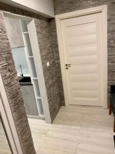 a kitchen with a white door and a stone wall at Apartament Catalin 1 in Arad