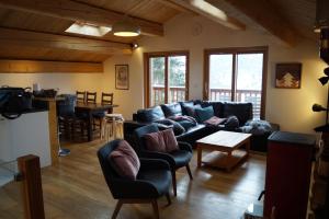 a living room with a couch and a table at Chalet soFlo -5 FLOCONS OR - 3 Vallées - Saint-Martin-de-Belleville-9personnes-130m2 in Saint-Martin-de-Belleville