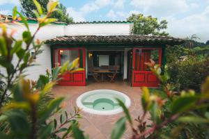 a small house with red doors and a patio at Termales El Otoño in Manizales