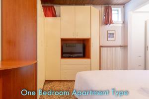 ein Schlafzimmer mit einem Bett und einem TV in einem Zimmer in der Unterkunft Santo Stefano Apartments - BolognaRooms in Bologna