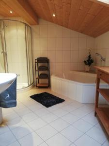 ein Badezimmer mit einer Badewanne und einem Waschbecken in der Unterkunft Ferienwohnung Hahnenkammblick in Kitzbühel