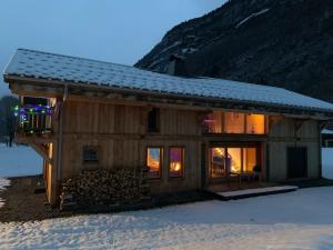 uma cabana de madeira na neve com uma montanha em LE DARMA em Sixt