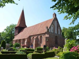 a church with two towers and a garden at Ferienwohnung Anne mit Sonnenterra in Altefähr