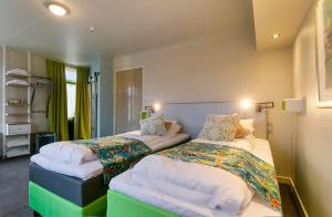 Dos camas en una habitación de hotel con una habitación en Bed & Breakfast Marrum, en Marrum