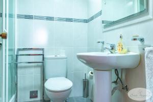 Un baño blanco con inodoro y lavabo. en Condo Magnolia, en Funchal 21 fotos más