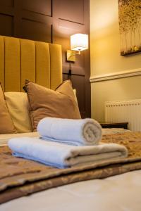 einen Stapel Handtücher auf dem Bett in der Unterkunft Abbey Court Guest House in Carlisle