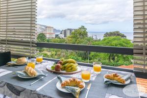 una mesa con platos de comida y zumo de naranja en Condo Magnolia, en Funchal