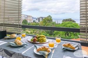 una mesa con platos de comida y jugo de naranja en Condo Magnolia, en Funchal