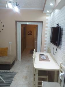 een eetkamer met een tafel en een tv aan de muur bij Friendly Apartment in Shkodër