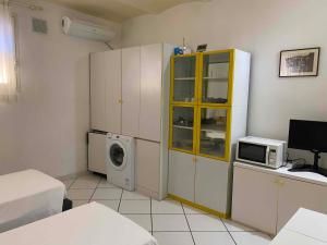 a kitchen with a washing machine and a microwave at Villa Alma in Bologna