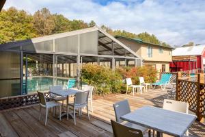 a patio with tables and chairs on a deck at Days Inn by Wyndham Murphy in Murphy