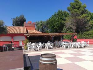un patio con sedie e tavoli e un padiglione di Vacargeles casa Les Mûriers et Les Chênes verts calme clim wifi animations piscine mini golf ad Argelès-sur-Mer