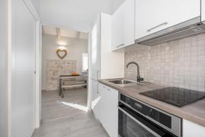 a white kitchen with a sink and a counter at Jully apartment with swimming pool in Babino Polje