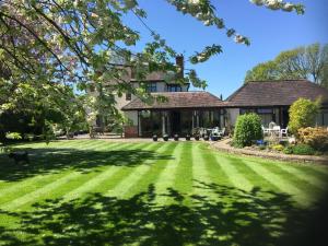 une maison avec une grande pelouse devant elle dans l'établissement Orchard Side Bed and Breakfast, à Great Malvern
