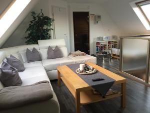 uma sala de estar com um sofá branco e uma mesa em Ferienwohnung Haagedoernchen em Nettetal