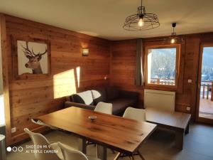 ein Wohnzimmer mit einem Tisch und einem Sofa in der Unterkunft LA BRESSE - Appartement de Charme in La Bresse