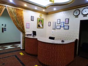 a lobby with a brick counter with clocks on the wall at سماء البريمى للشقق الفندقية in Ţawī ‘Aqdah