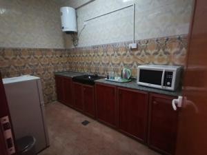 a kitchen with a microwave and a sink at سماء البريمى للشقق الفندقية in Ţawī ‘Aqdah