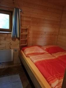 um quarto com uma cama num chalé de madeira em Selbstversorger Hütte Rechberg em Rechberg