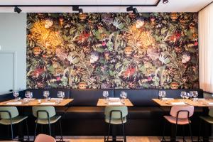 a wall mural in a restaurant with tables and chairs at Hotel De Zes Bochten in Knokke-Heist