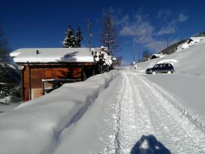 ein Auto, das auf einer schneebedeckten Straße fährt in der Unterkunft Chalet Edelweiss in Hérémence