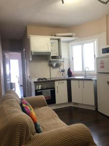 a living room with a couch and a kitchen at Atico La Laguna con terraza y vistas in Las Lagunas