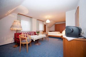una camera con letto e una camera con TV di Landgasthof-Pension Ochsen a Forbach