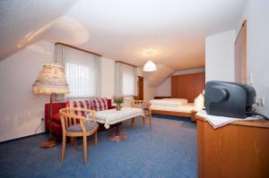 ein Hotelzimmer mit einem Bett und ein Zimmer mit einem TV in der Unterkunft Landgasthof-Pension Ochsen in Forbach