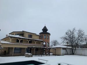 een huis met een zwembad in de sneeuw bij Casafamiglia in Prolesha