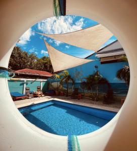 a swimming pool looking through a hole in a building at Blue Iguana in Sámara