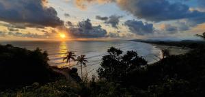 a view of a beach with the sun setting at HosteLife Gokarna in Gokarna