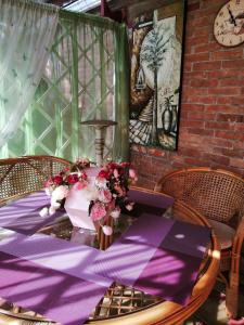 エイスクにあるдом для отпуска на Ростовскойの紫のテーブルクロスと花のテーブル