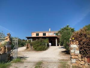 a large house with a driveway in front of it at Villa Su Trechesu in Orosei