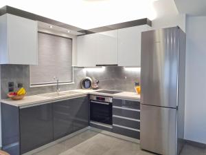 a kitchen with white cabinets and a stainless steel refrigerator at Four Seasons Homes in Stalos