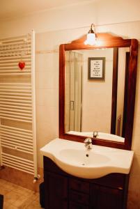 W łazience znajduje się umywalka, lustro i prysznic. w obiekcie Maisonette w mieście Nus