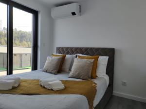 een slaapkamer met een groot bed en een groot raam bij Apartment - Vista Alegre in Ponte de Lima