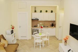 een keuken en een woonkamer met een tafel en stoelen bij DOMUS DIVI - appartamento nel cuore di Roma in Rome