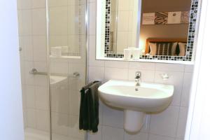 een badkamer met een wastafel en een douche bij Hotel Kickert in Mettendorf